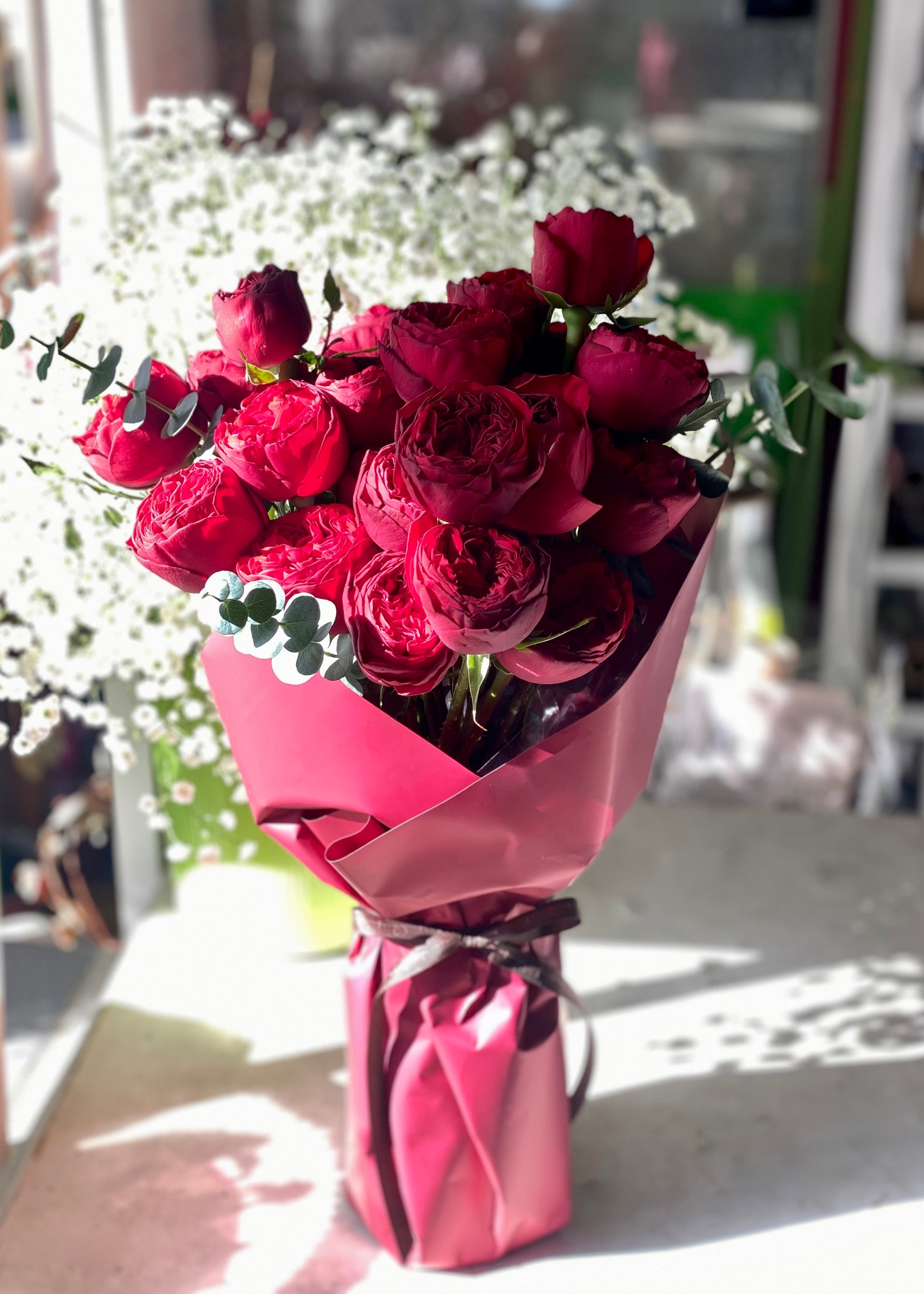24 red roses hand-tied bouquet with greenery